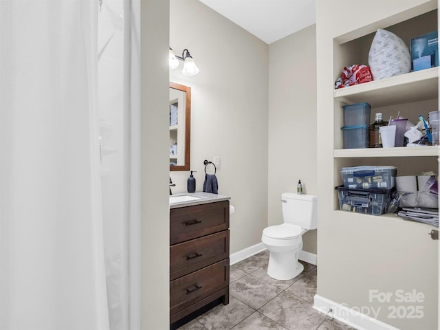 bathroom with toilet, vanity, and tile patterned floors