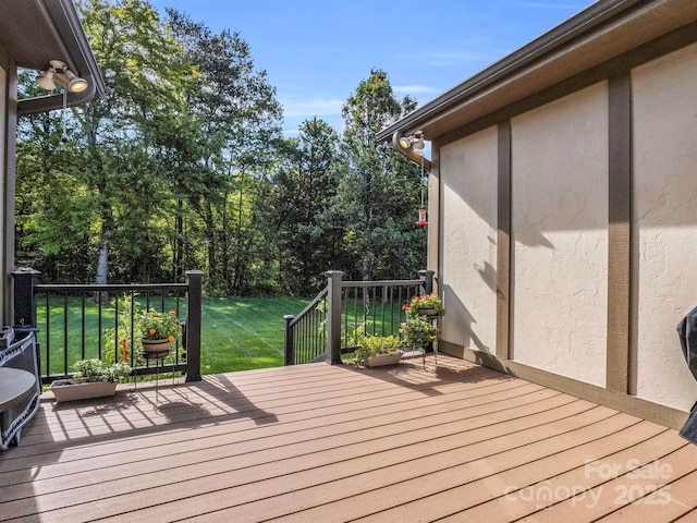 wooden terrace featuring a lawn