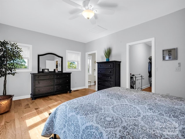 bedroom featuring ensuite bath, ceiling fan, and light wood-type flooring