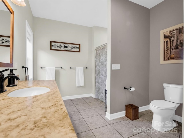 bathroom with tile patterned flooring, vanity, and toilet