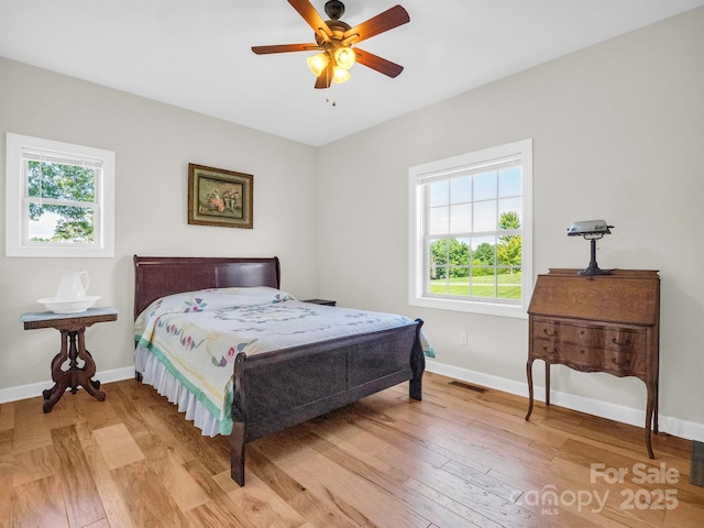 bedroom featuring multiple windows, light hardwood / wood-style flooring, and ceiling fan