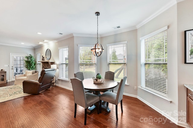 dining room featuring dark hardwood / wood-style flooring, ornamental molding, and an inviting chandelier