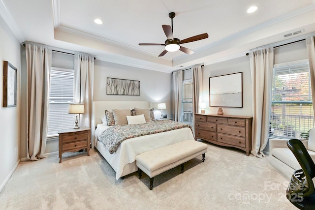 bedroom with ceiling fan, a raised ceiling, light carpet, and crown molding