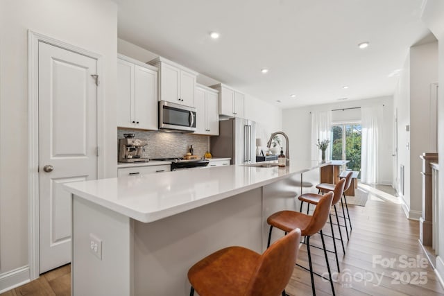 kitchen featuring a large island, sink, a kitchen bar, and stainless steel appliances