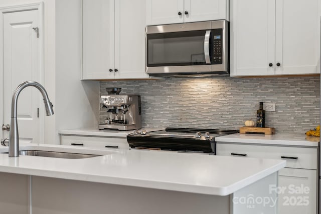 kitchen featuring sink, white cabinetry, stainless steel appliances, and tasteful backsplash