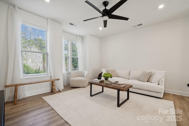 living room with light wood-type flooring and ceiling fan