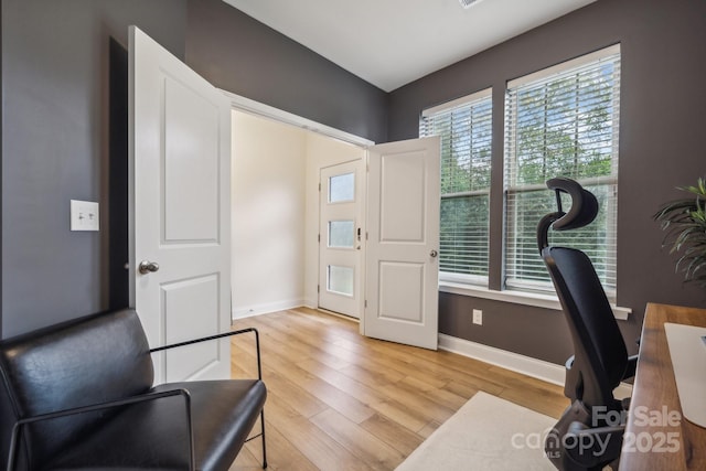 office space featuring light wood-type flooring and a healthy amount of sunlight