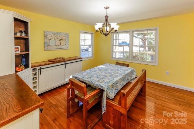 dining space featuring light hardwood / wood-style floors and an inviting chandelier