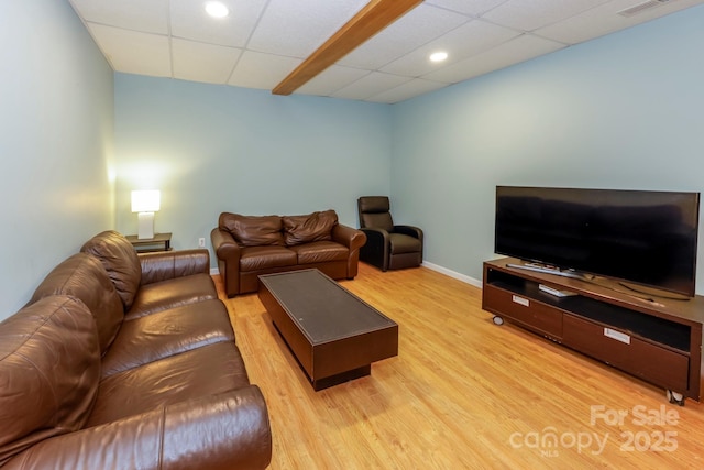 living room featuring a paneled ceiling and light hardwood / wood-style flooring