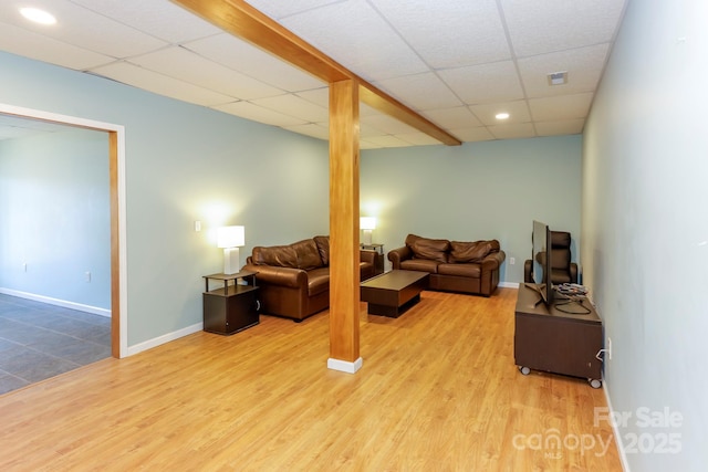 living room with a paneled ceiling and light hardwood / wood-style flooring