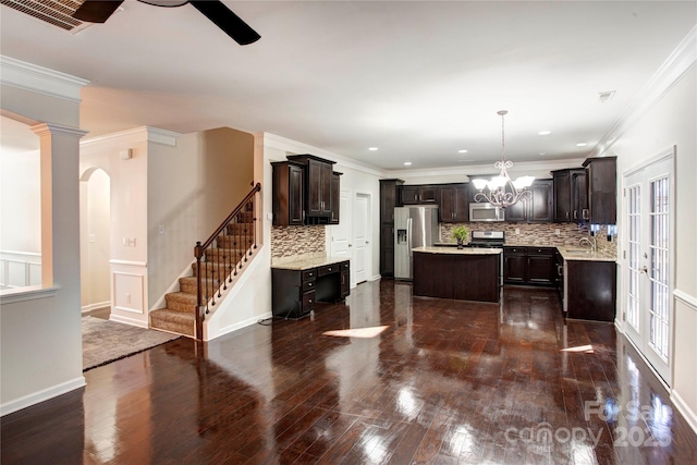 kitchen featuring tasteful backsplash, dark brown cabinetry, a kitchen island, and appliances with stainless steel finishes