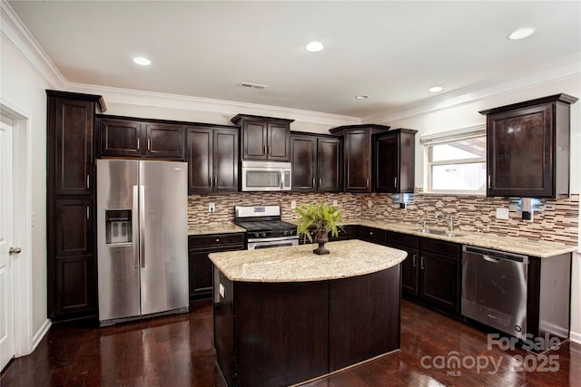 kitchen featuring a center island, dark wood-type flooring, sink, appliances with stainless steel finishes, and dark brown cabinetry