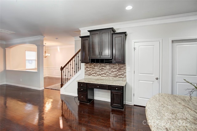 kitchen featuring ornate columns, decorative backsplash, light stone counters, and ornamental molding