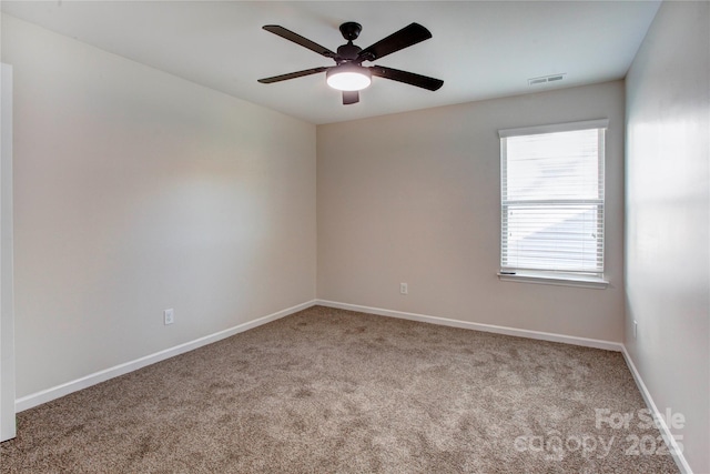 spare room featuring light carpet and ceiling fan