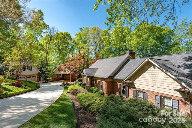 craftsman inspired home featuring roof with shingles, a chimney, and brick siding