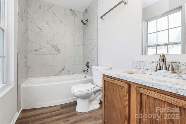 full bathroom featuring toilet, vanity, tiled shower / bath combo, and hardwood / wood-style flooring