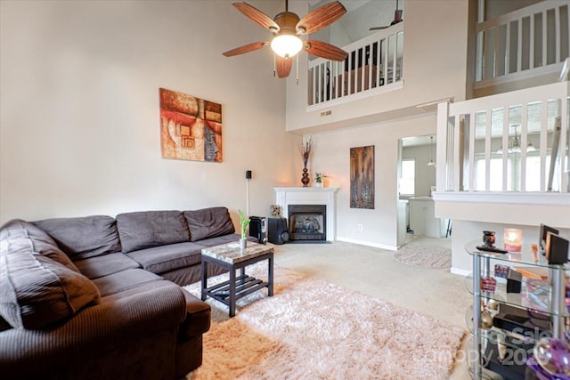 living room featuring carpet flooring, a high ceiling, and ceiling fan