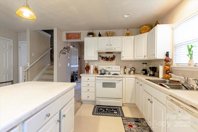 kitchen featuring pendant lighting, white appliances, white cabinetry, and sink