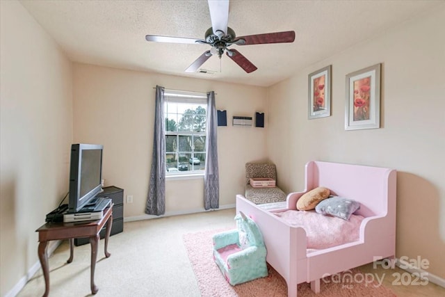 bedroom featuring ceiling fan, light carpet, and a textured ceiling