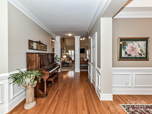 interior space with ornate columns, hardwood / wood-style floors, and ornamental molding