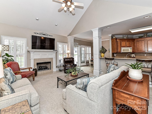 living room featuring a tile fireplace, high vaulted ceiling, ceiling fan, and a healthy amount of sunlight