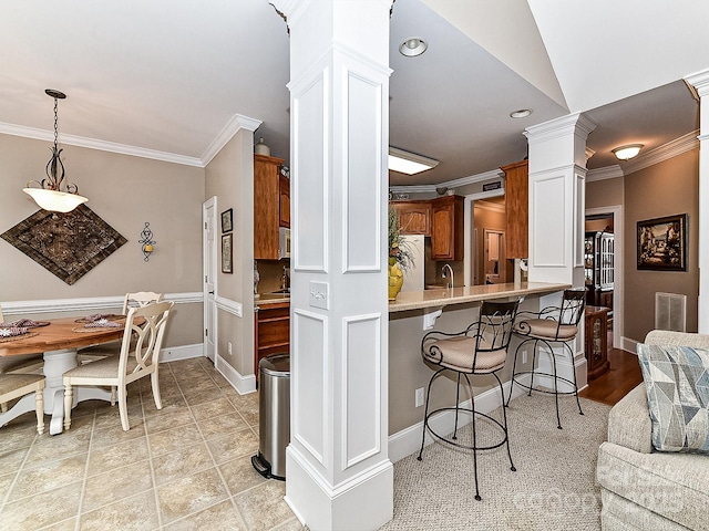 kitchen with a breakfast bar, refrigerator, kitchen peninsula, and ornamental molding