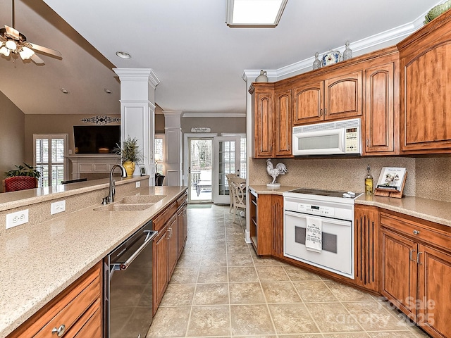 kitchen with white appliances, sink, decorative backsplash, ornamental molding, and ornate columns