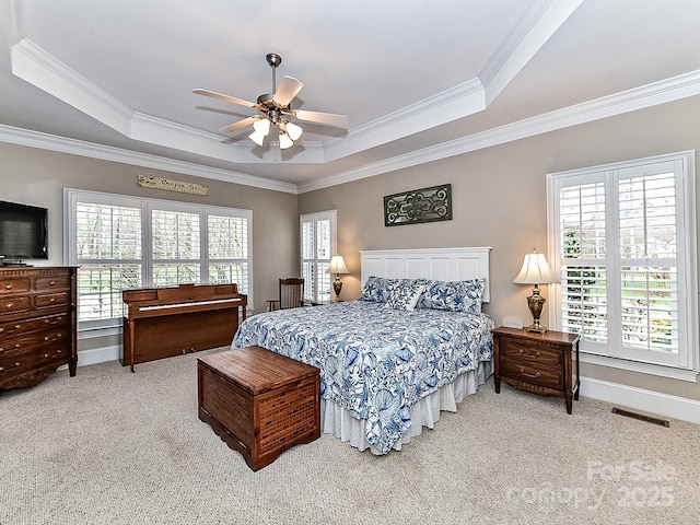 bedroom with ceiling fan, a raised ceiling, and ornamental molding