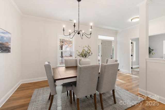 dining area featuring hardwood / wood-style flooring, crown molding, and a chandelier