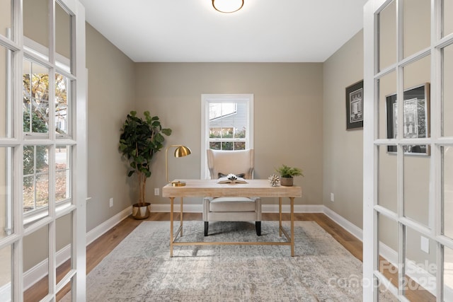 home office with light hardwood / wood-style flooring