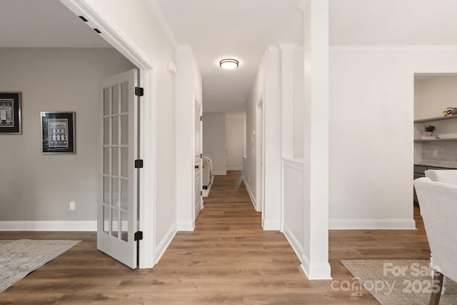 hallway featuring light hardwood / wood-style floors and ornamental molding