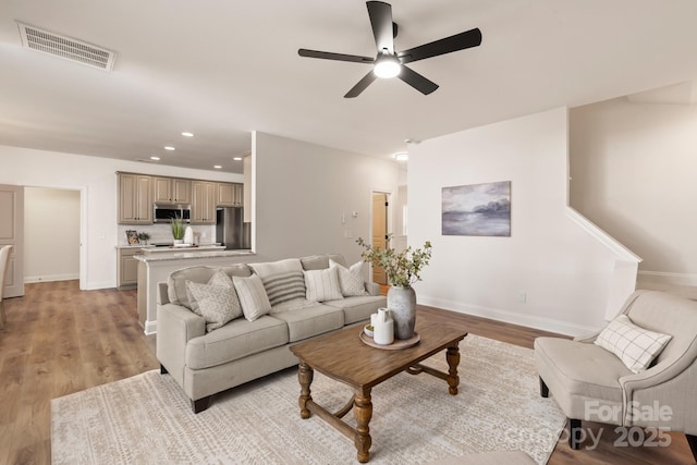 living room with ceiling fan and light wood-type flooring