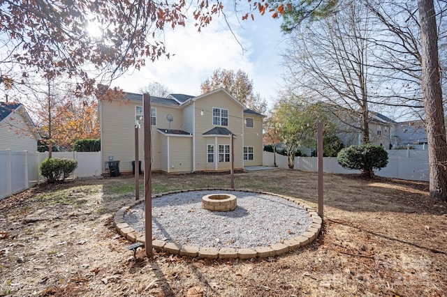 back of property featuring central air condition unit and a fire pit