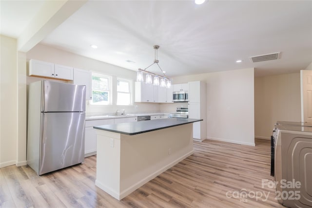 kitchen with white cabinets, stainless steel appliances, and a kitchen island