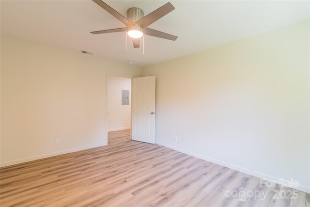 spare room featuring light wood-type flooring, electric panel, and ceiling fan