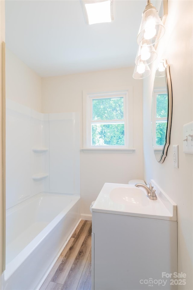 bathroom with shower / bathing tub combination, wood-type flooring, and vanity