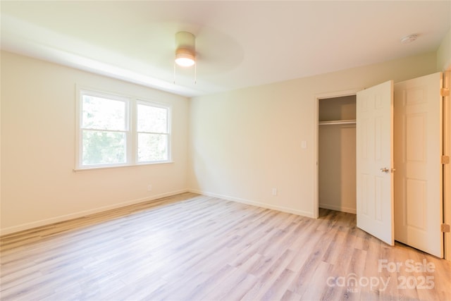 unfurnished bedroom with ceiling fan, light hardwood / wood-style flooring, and a closet