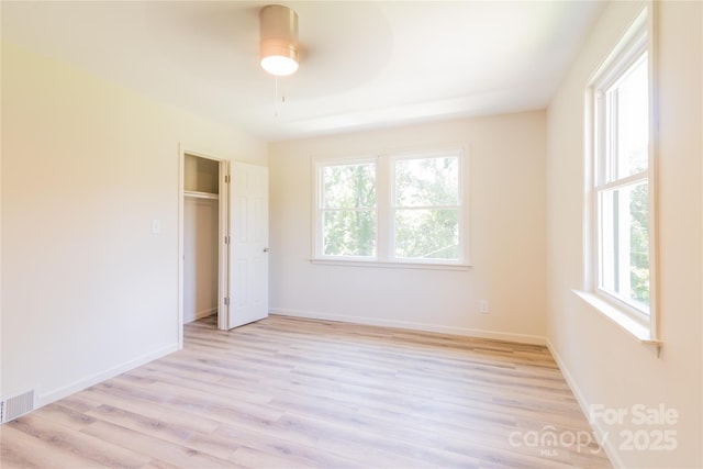 unfurnished bedroom with ceiling fan, a closet, and light wood-type flooring