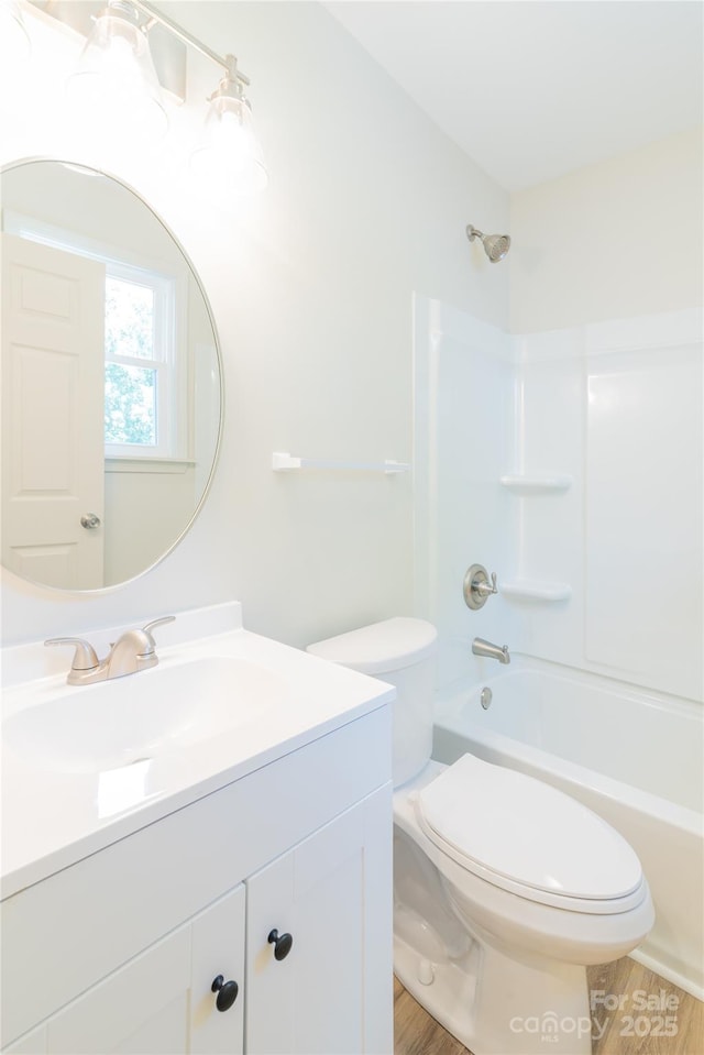 full bathroom featuring bathtub / shower combination, hardwood / wood-style floors, vanity, and toilet