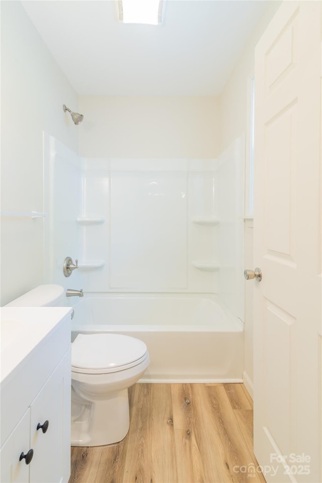 full bathroom with hardwood / wood-style floors, vanity, toilet, and shower / washtub combination