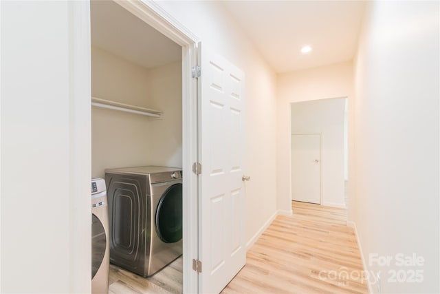 laundry room with light wood-type flooring and separate washer and dryer