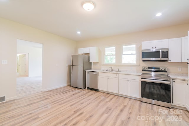 kitchen with white cabinetry and appliances with stainless steel finishes