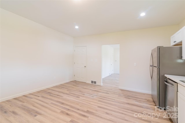 kitchen featuring light hardwood / wood-style flooring, white cabinets, and stainless steel dishwasher