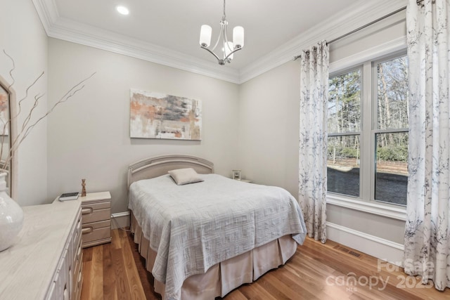 bedroom featuring an inviting chandelier, dark wood-type flooring, and ornamental molding