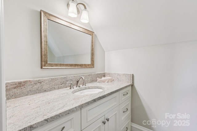 bathroom with vanity and vaulted ceiling