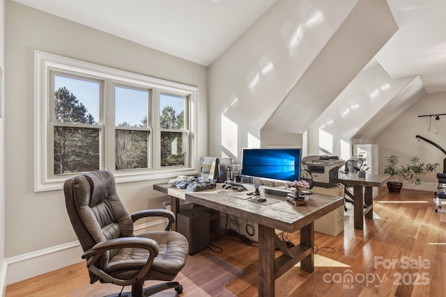 office area with light wood-type flooring and lofted ceiling