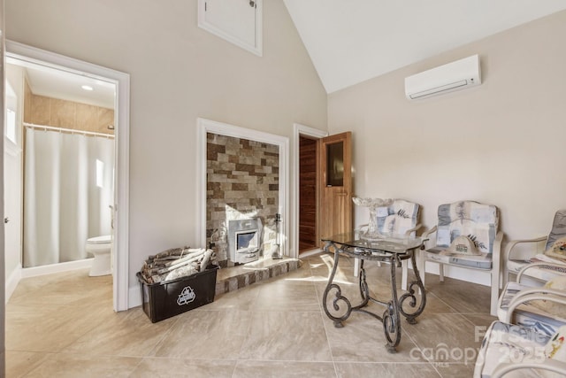 living area featuring a wood stove, high vaulted ceiling, and a wall mounted air conditioner