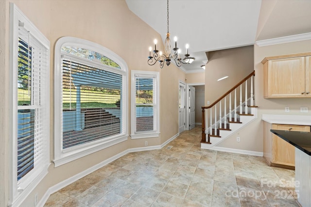 foyer entrance featuring vaulted ceiling, an inviting chandelier, and crown molding