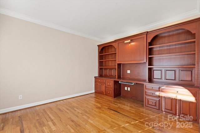 unfurnished office with built in desk, crown molding, and light hardwood / wood-style flooring