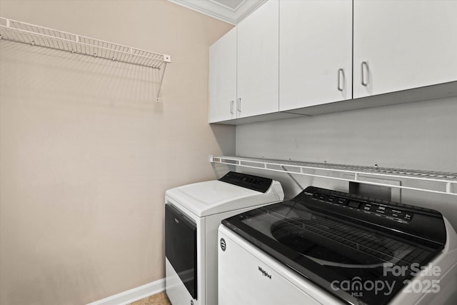 washroom with cabinets, ornamental molding, and washing machine and dryer